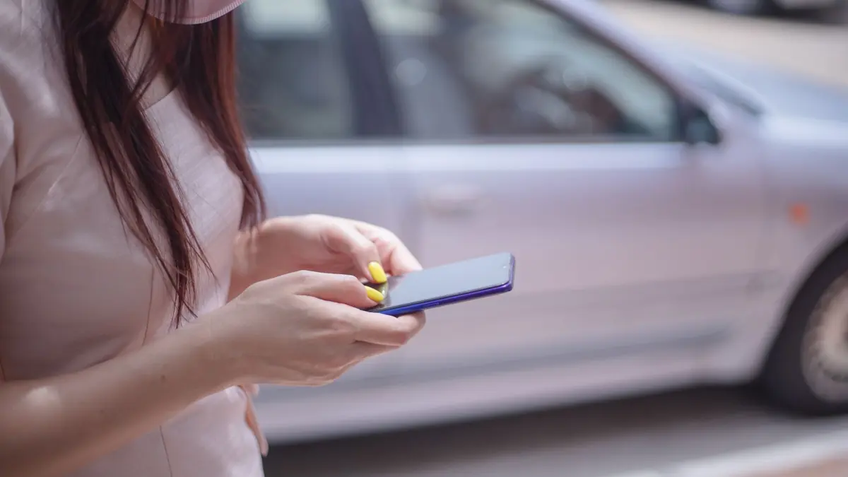 Mulher lendo uma mensagem no celular na rua